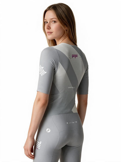Female cyclist wearing a grey False Flat x Castelli Sanremo speedsuit with aerodynamic ribbed sleeves and back panels